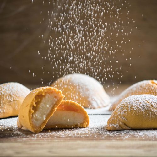 Empanadas de leche | Pastelería Ciro Guatemala | Elaboradas con masa de harina de arroz, suave y ligeramente crujiente, estas empanadas encierran un generoso relleno de manjar de leche perfumado con canela y pasas. Una receta de herencia italiana que evoca el calor del hogar desde hace más de 50 años.