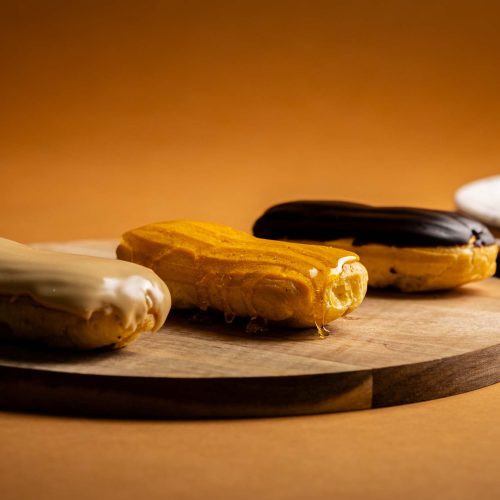 Relámpagos | Pastelería Ciro Guatemala | Clásicos eclairs de pasta choux horneados a la perfección, rellenos con nuestro suave manjar de leche artesanal. Disponibles con tres coberturas: chocolate oscuro, caramelo dorado o mocca intenso. Una pieza de pastelería italiana en su mejor expresión.