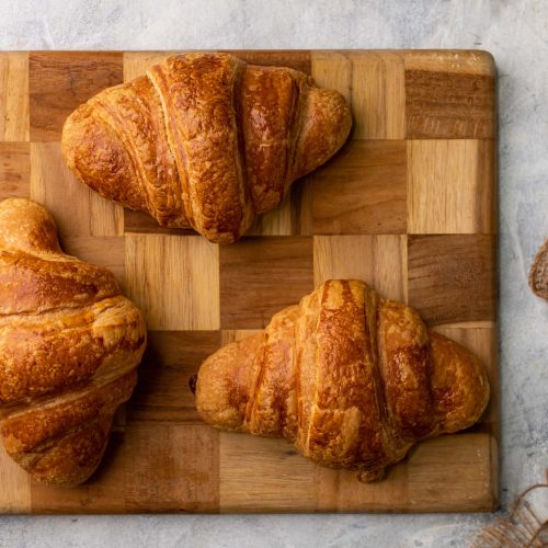 Croissant jamón y queso | Pastelería Ciro Guatemala | Croissant artesanal de masa laminada con mantequilla importada, dorado y crujiente por fuera con capas aireadas por dentro, relleno de jamón de pavo seleccionado y queso chédar fundido. Un croissant salado que es al mismo tiempo sustancioso y refinado.