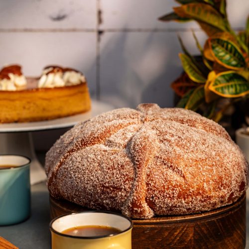Pan de Muerto | Pastelería Ciro Guatemala | Tradicional y lleno de sabor, nuestro pan de muerto está elaborado con una suave masa enriquecida con mantequilla sin sal que le brinda una textura esponjosa y delicada. La esencia de naranja aporta un aroma caracteristico y un toque cítrico que realza su sabor único. Ideal para disfrutar en cualquier ocasión, es un clásico que combina tradición y calidad.