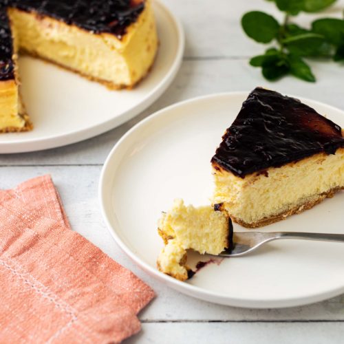 Cheesecake de arandanos | Pastelería Ciro Guatemala | Cheesecake horneado de textura suave y cremosa, sobre base de galleta artesanal, coronado con salsa de arándanos de sabor frutal y ligeramente ácido que equilibra perfectamente la dulzura del queso crema.