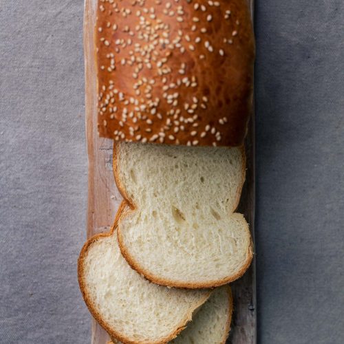 Pan de molde | Pastelería Ciro Guatemala | Pan de molde artesanal de miga suave y uniforme, horneado en casa con masa fermentada lentamente y cubierto de semillas de ajonjolí. Una alternativa artesanal al pan industrial que se nota desde el primer bocado.