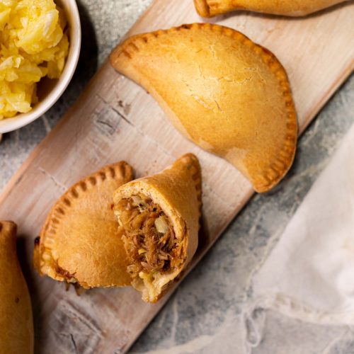 Empanada al pastor | Pastelería Ciro Guatemala | Empanada horneada con masa salada a base de mantequilla, rellena de pollo marinado al estilo al pastor: una mezcla de especias molidas en casa, piña natural y chile suave que dan como resultado un relleno jugoso y lleno de carácter. Tradición mexicana reinterpretada con el cuidado artesanal de Ciro.